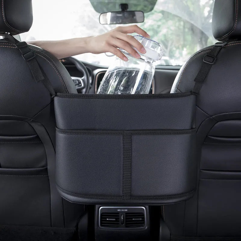 Black leather car seat storage bag with carbon fibre pattern, 38cm long, placed in middle of car seat