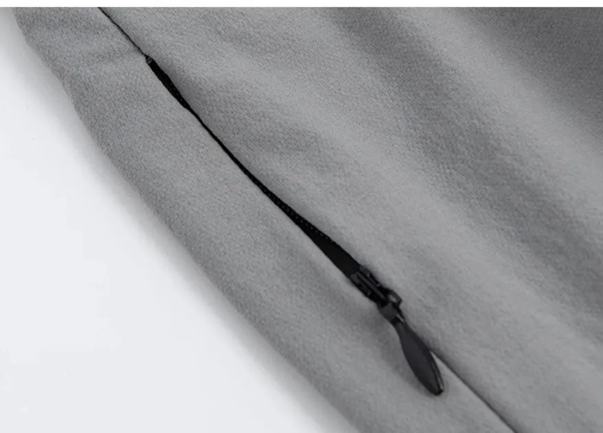 Loose fit grey sports cropped pants with a printed elastic waistband, shown on a model.