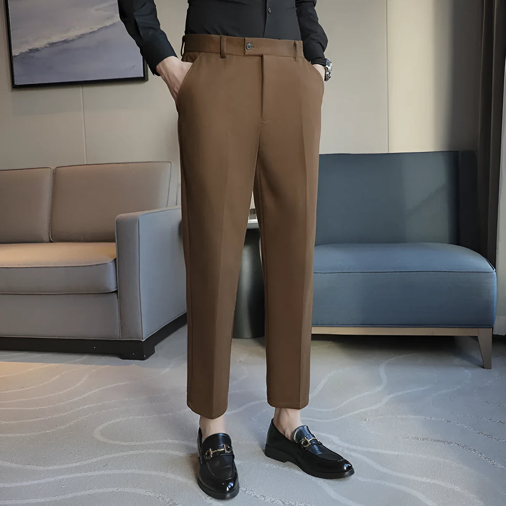 Straight leg brown corduroy trousers with an elasticated waistband on a hanger.