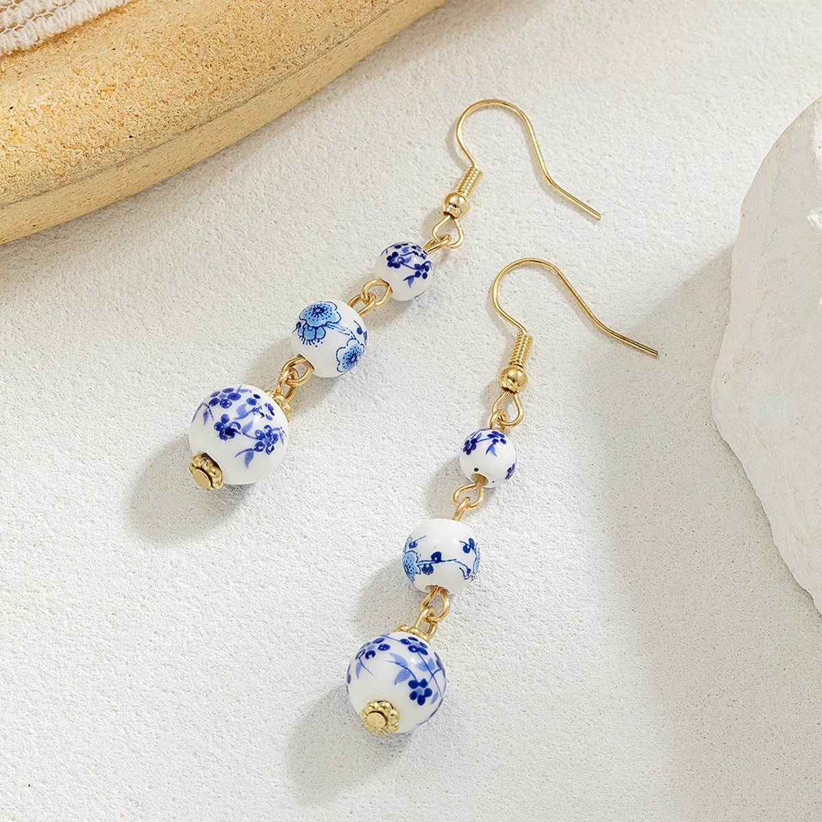 Long blue and white porcelain ceramic bead retro geometric earrings with alloy electroplated frame.