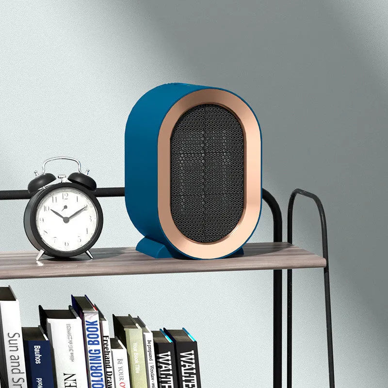 Small black portable ceramic fan heater with UK plug on a wooden desk