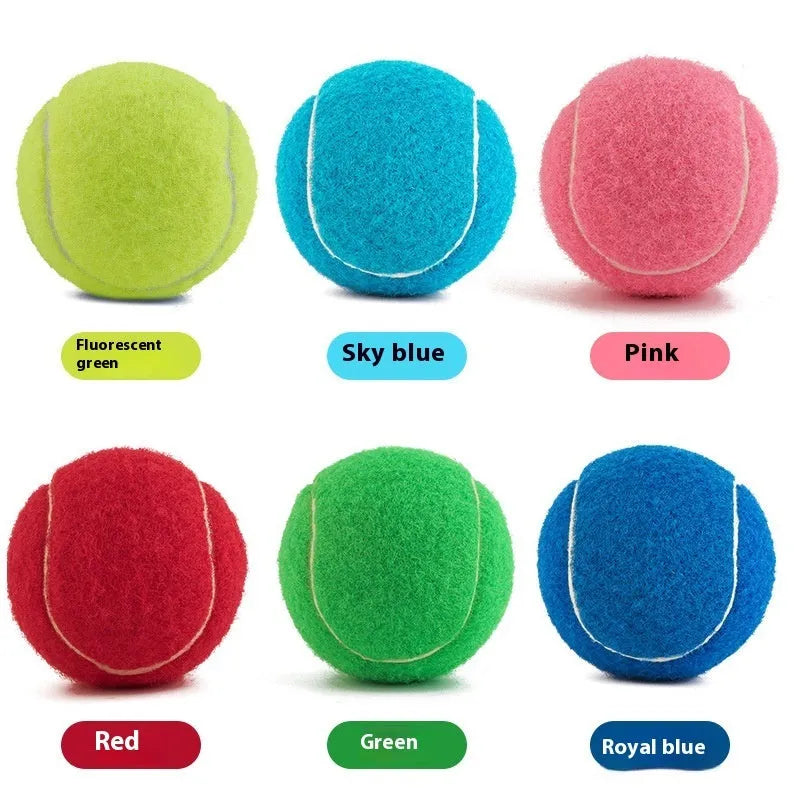 A 6.3cm pink rubber dog tennis ball sitting on grass.