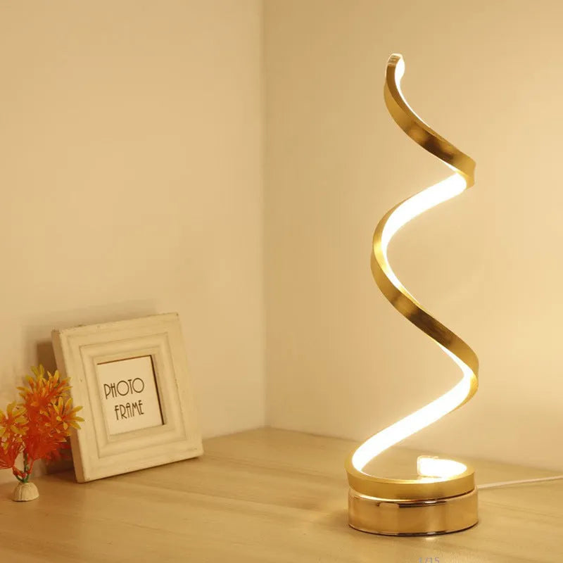 Minimalist black and white LED bedside lamp with aluminium shade and tri-colour dimming on a wooden table.