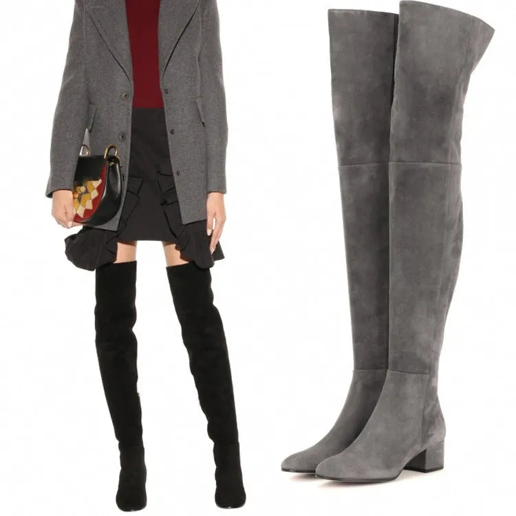 Women's grey suede over-the-knee flat boots with low heel and pointed toe on a neutral background