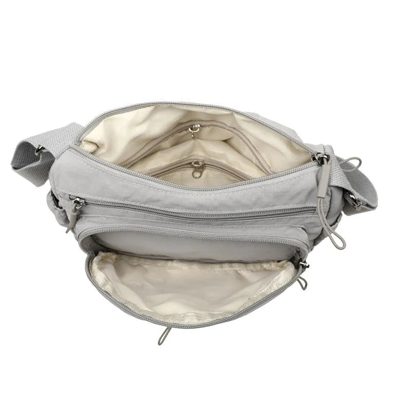Soft water-repellent nylon crossbody bag in grey with a front 3D pocket.