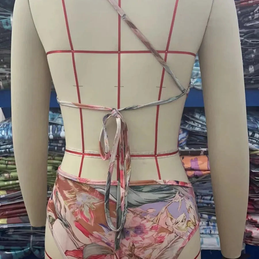 Women's rose gold patterned swimsuit on a hanger.