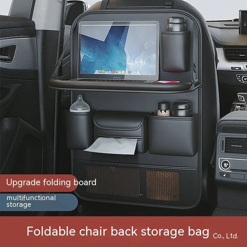 Black leather car seat storage bag with a foldable dining table deployed, hanging behind a car headrest