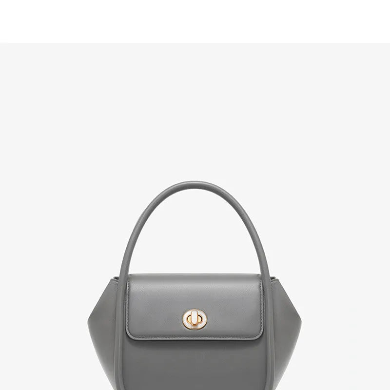 Leather tote cross-body wing bag in soft cow leather with latch closure and wing shape design.