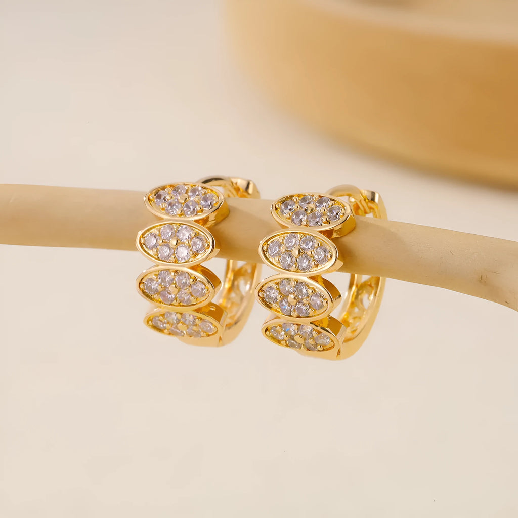 Gold-coloured women's stud earrings with zircon stone detailing on zirconium settings