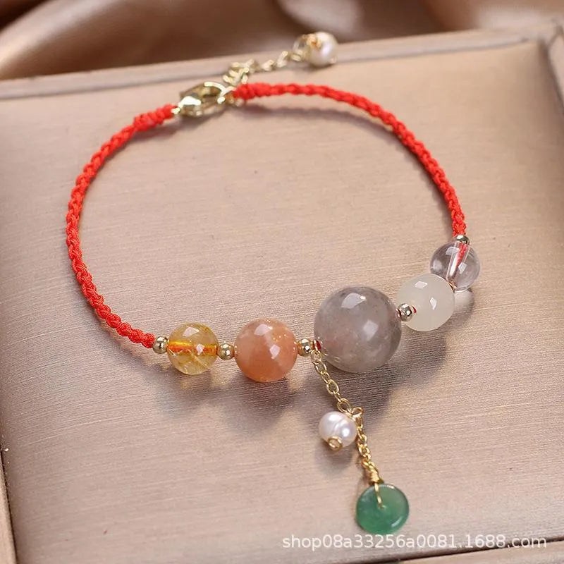 Women's hand-woven crystal and sequin bracelet with a silver peace buckle fastening on a wrist.