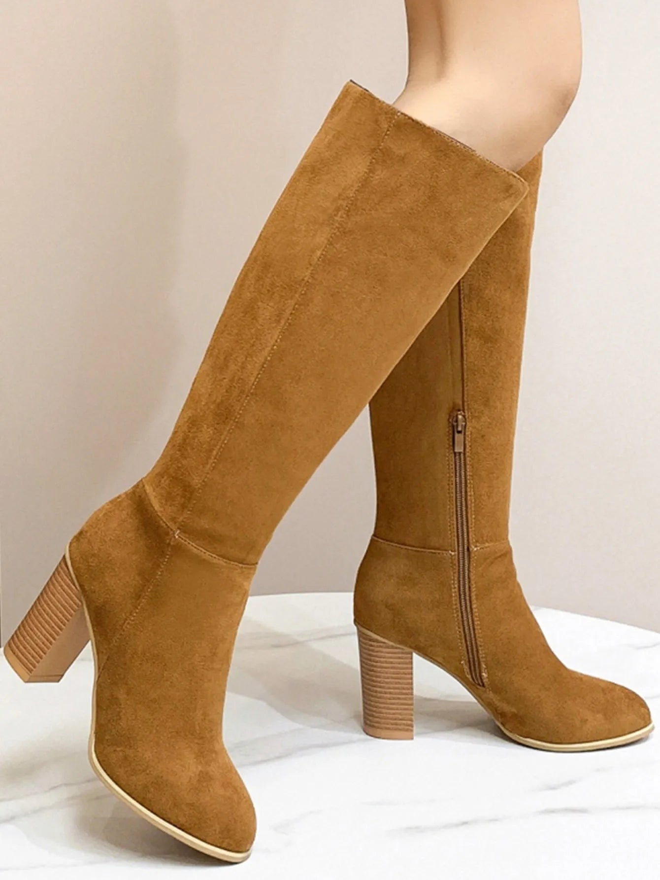 Women's black square toe ankle boots with a block heel on a wooden floor.