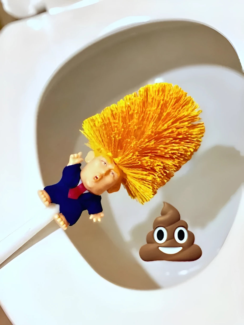 Yellow plastic Trump novelty toilet brush with a hanging slot on the handle.