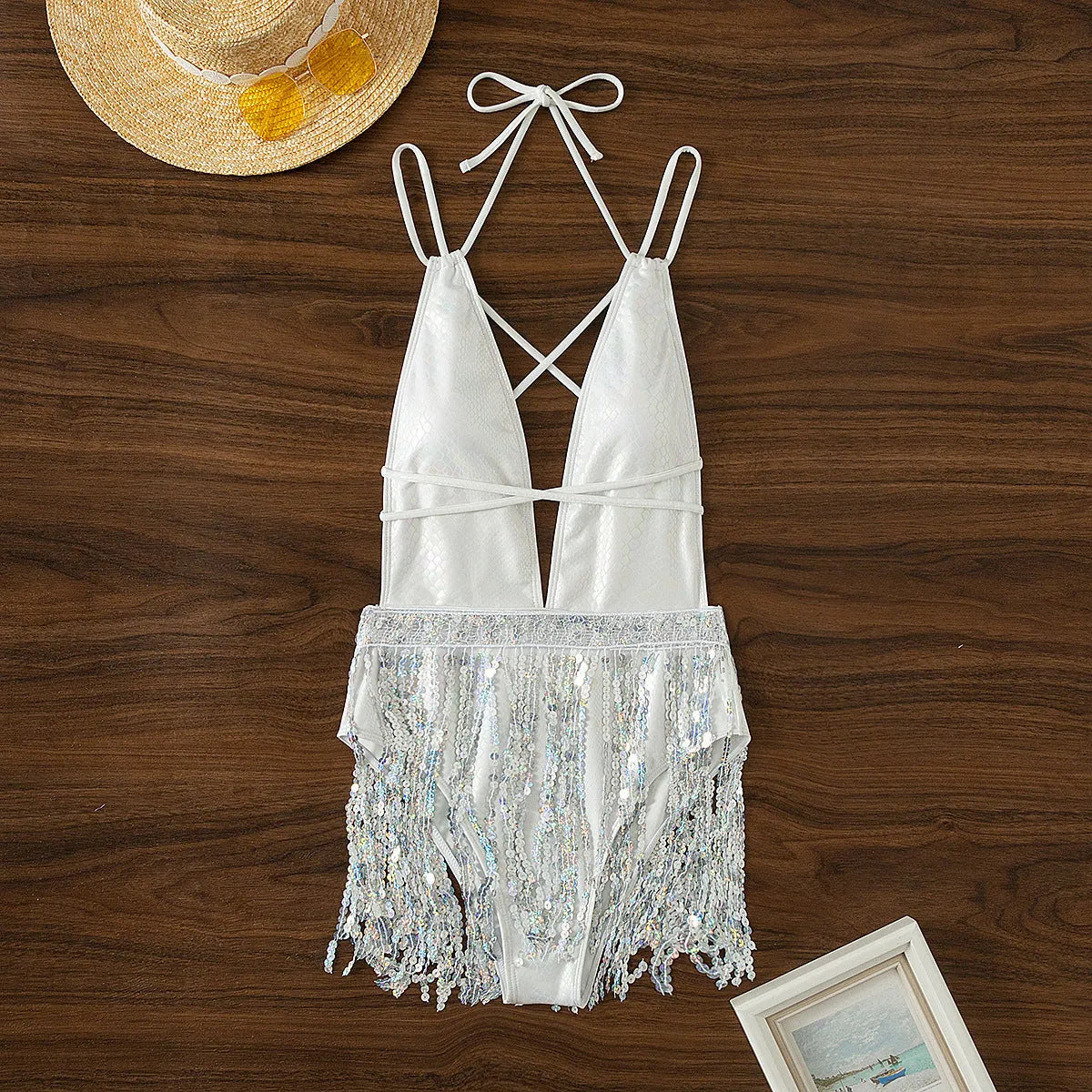 White one-piece swimsuit with deep V-neck, adjustable halter straps, and a long front tassel.