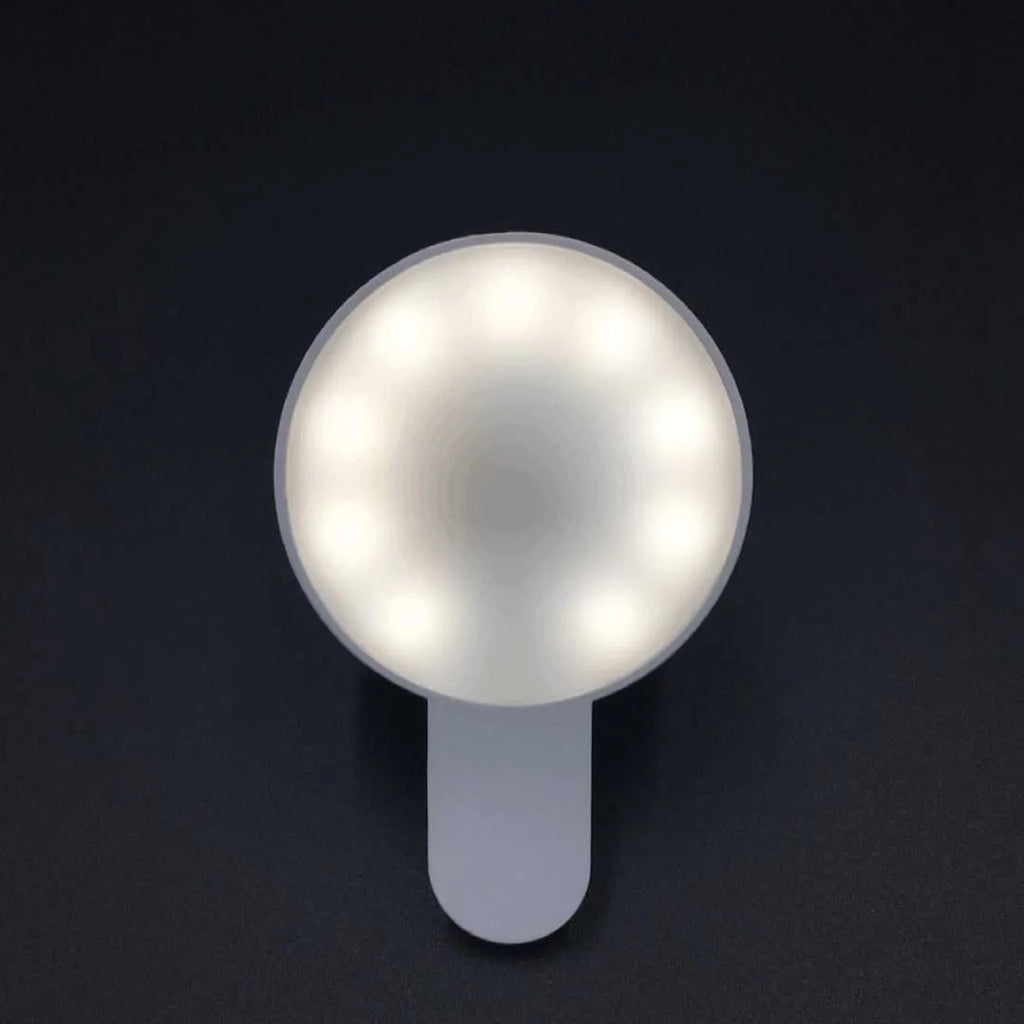 White clip-on LED selfie light for mobile phones showing three-level dimming buttons and USB port.