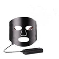 Black and gold LED phototherapy face mask with controller on a white background.