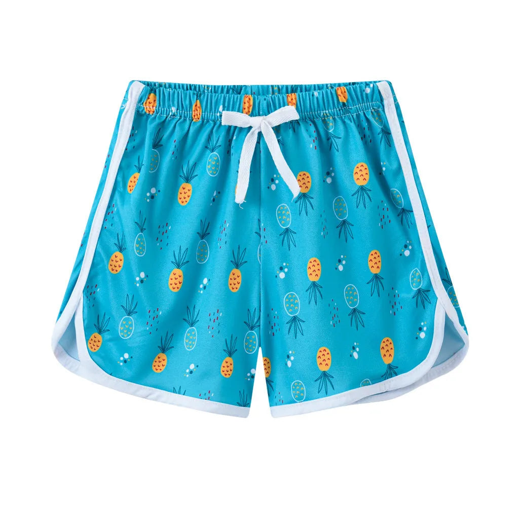 Children's beach shorts in multiple colours and patterns including pineapple print and solid colours