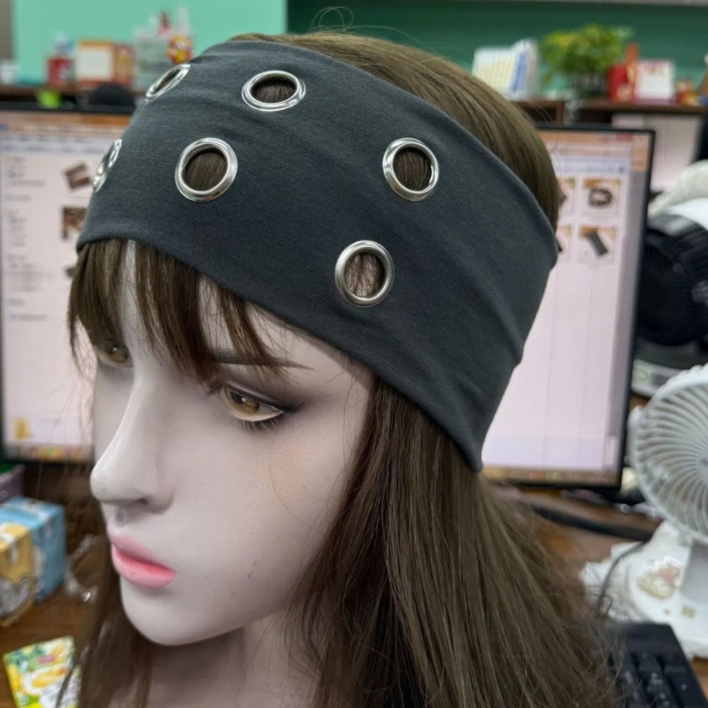 Close-up of a black polyester pullover hair band with a silver hollow metal circle decoration on a model.