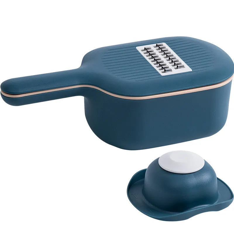 Dark blue vegetable cutter kitchen tool with hand guard, four stainless steel blades, and a white drain basket.