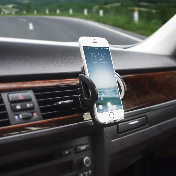 Black plastic mobile phone holder attached to car air conditioning vent with phone secured