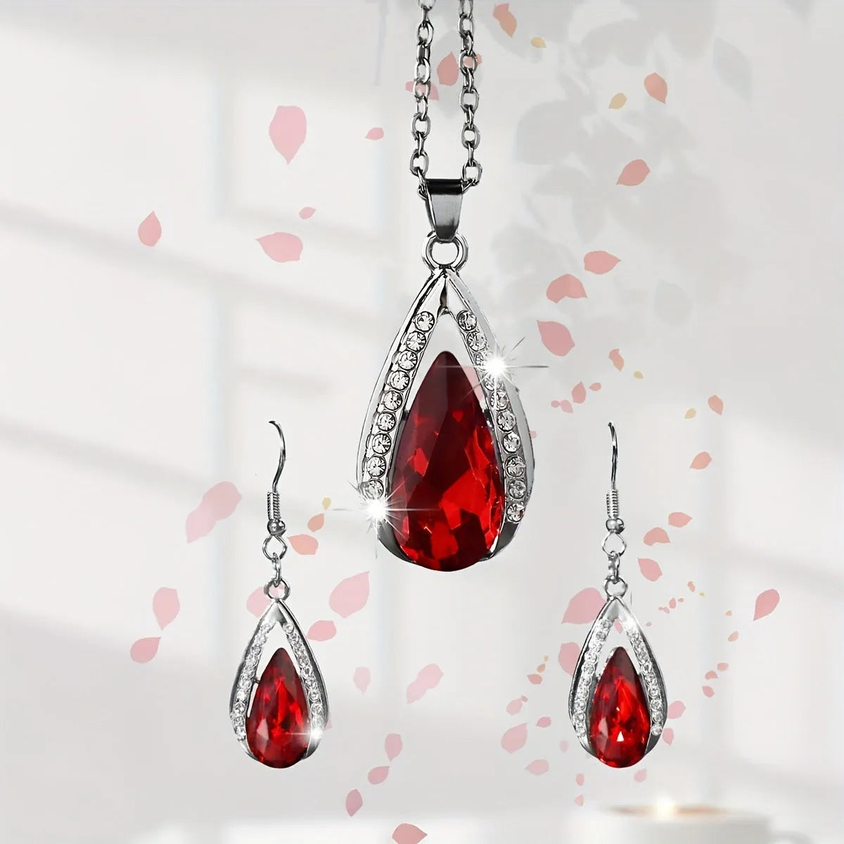 Black and red teardrop glass pendant necklace with matching earrings set on display