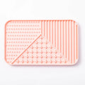 Grey silicone pet licking mat with textured surface and a white suction cup on the back.