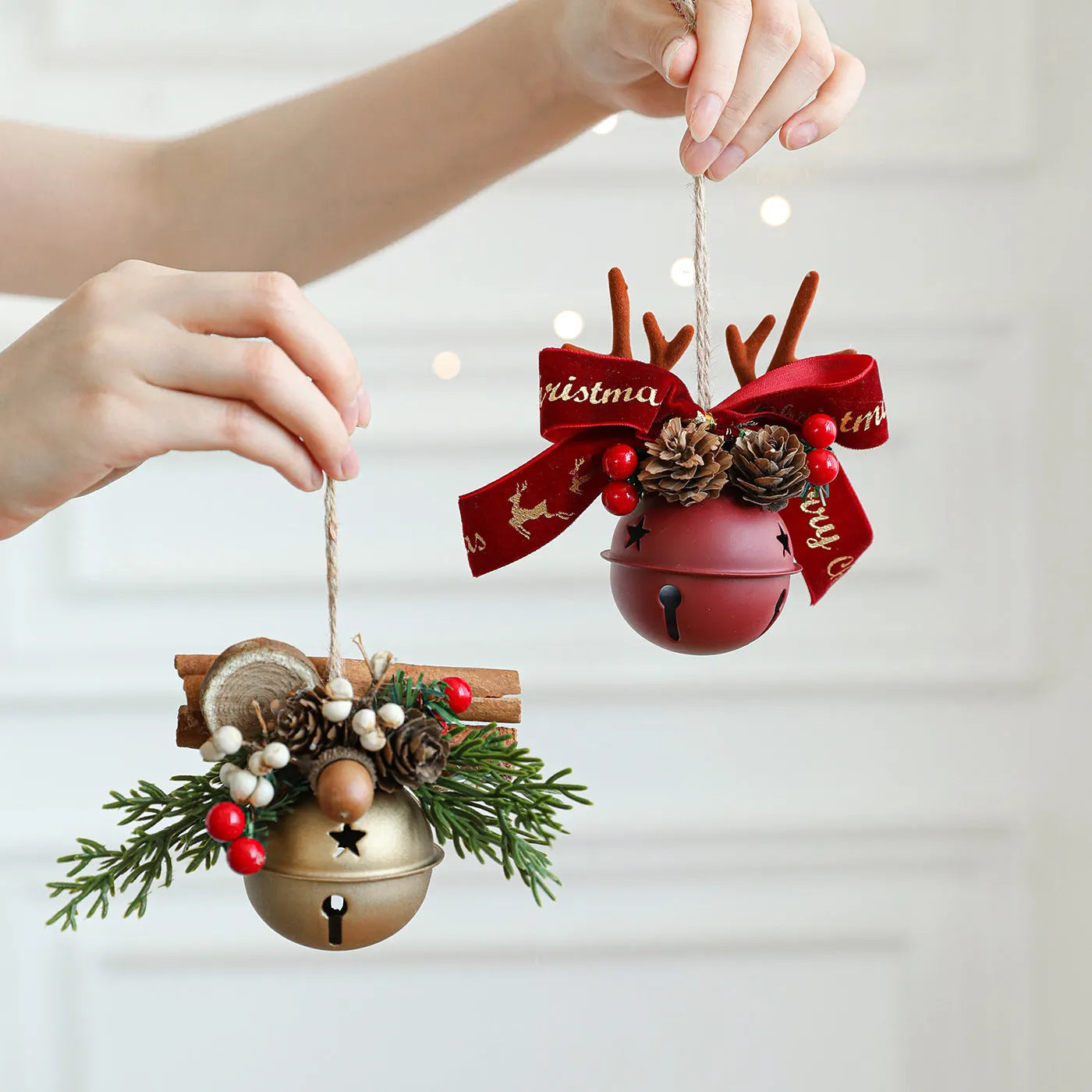 Wrought iron window hanging ornament with a jingling bell, antlers, and pine cone design in a choice of colours.