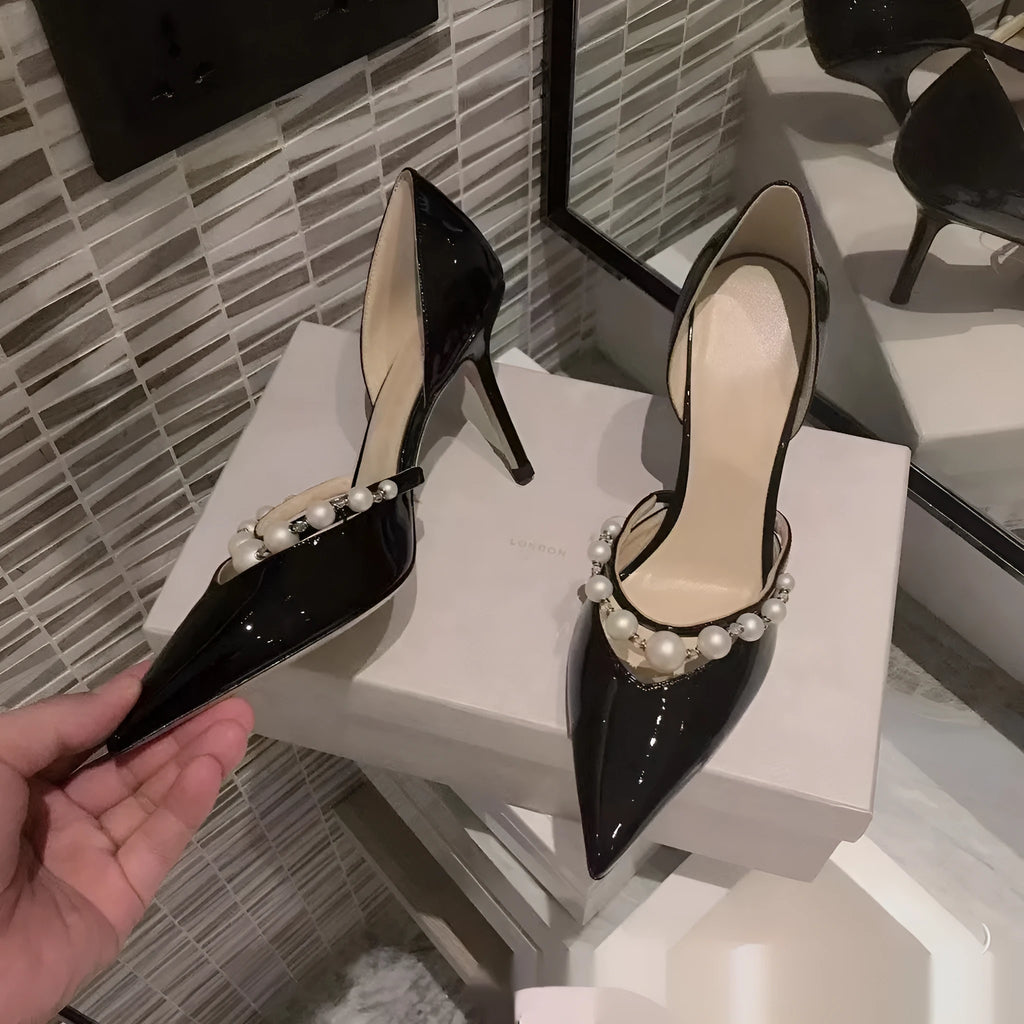 Women's pointed toe patent leather stiletto high heels with pearl decoration on the upper.