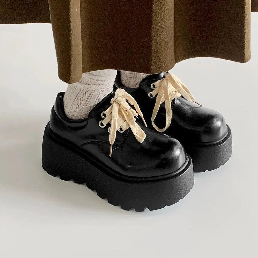 Women's matte black lace-up shoes with a 6-8cm English muffin heel and round toe on a solid background