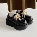 Women's matte black lace-up shoes with a 6-8cm English muffin heel and round toe on a solid background
