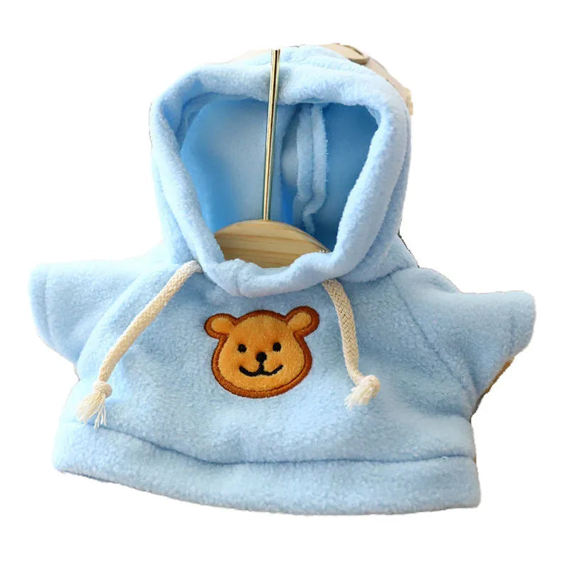A dog wearing a blue hooded cloth sweater, showing the hood up and the garment's fit.