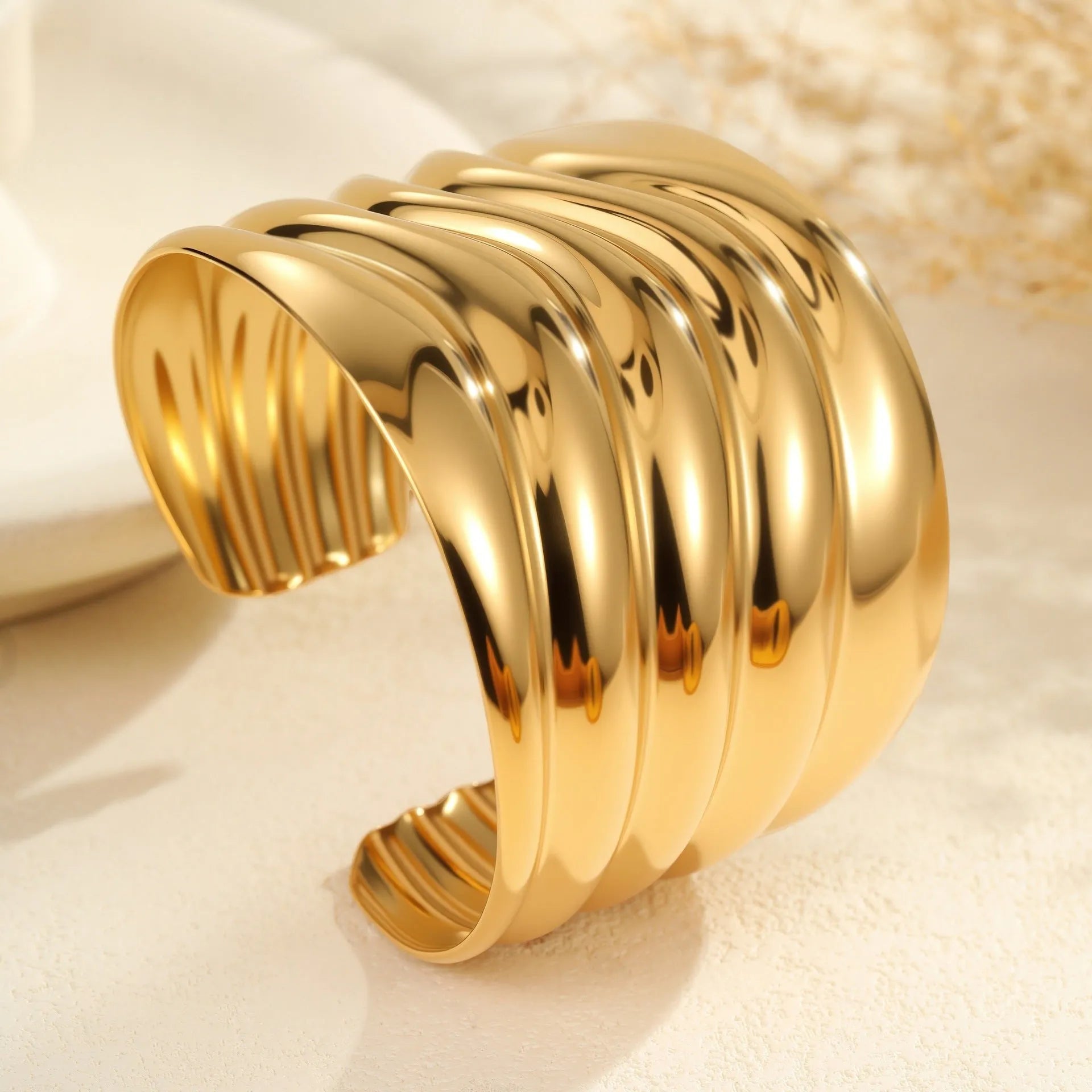 Gold plated wide women's bracelet with asymmetric geometric design and a niche opening.