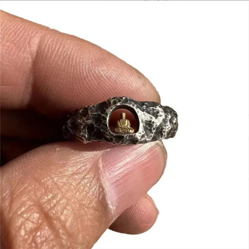 Hand-forged copper ring with rock texture surface and Buddha element, showing hammer marks and matte finish