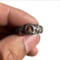Hand-forged copper ring with rock texture surface and Buddha element, showing hammer marks and matte finish