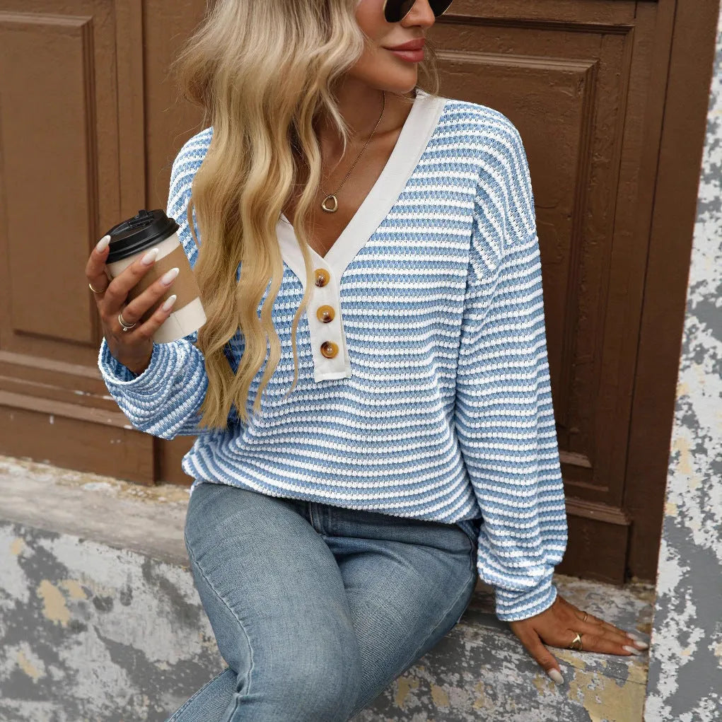A woman's loose-fitting V-neck pullover top with long sleeves and patchwork detailing.