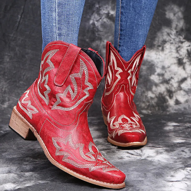 Women's blue cowboy boots with embroidery, wedge heel, and pointed toe on a neutral background
