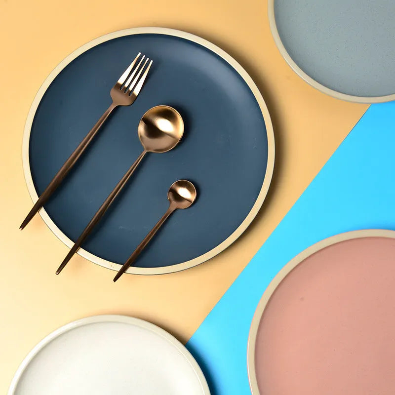 A 10-inch diameter pure blue matte ceramic dinner plate with a subtle textured finish on a wooden table.