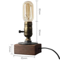 Water pipe table lamp with wood and iron construction, 9 cm wide and 13 cm tall, on a bedside table