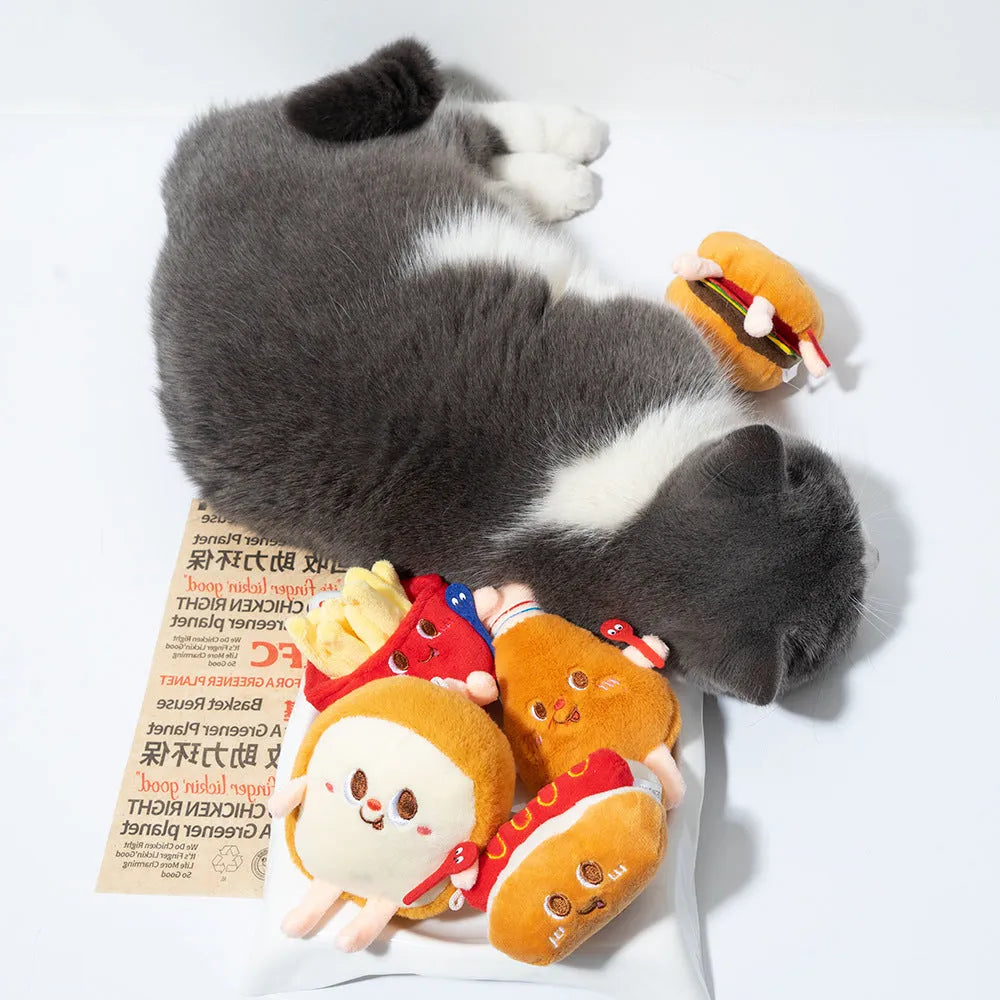 Set of five colourful cat chewing toys shaped like hamburger, chicken legs, fries, hot dog, and bread slice on a white background.