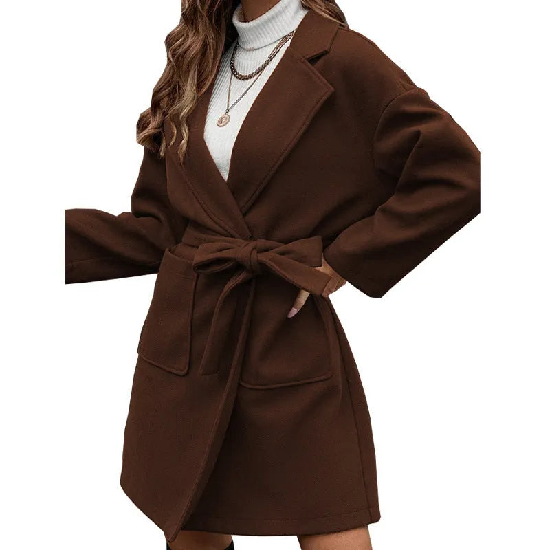 Minimalist long sleeve lapel coat with a split belt in a light blue colour, shown on a model.