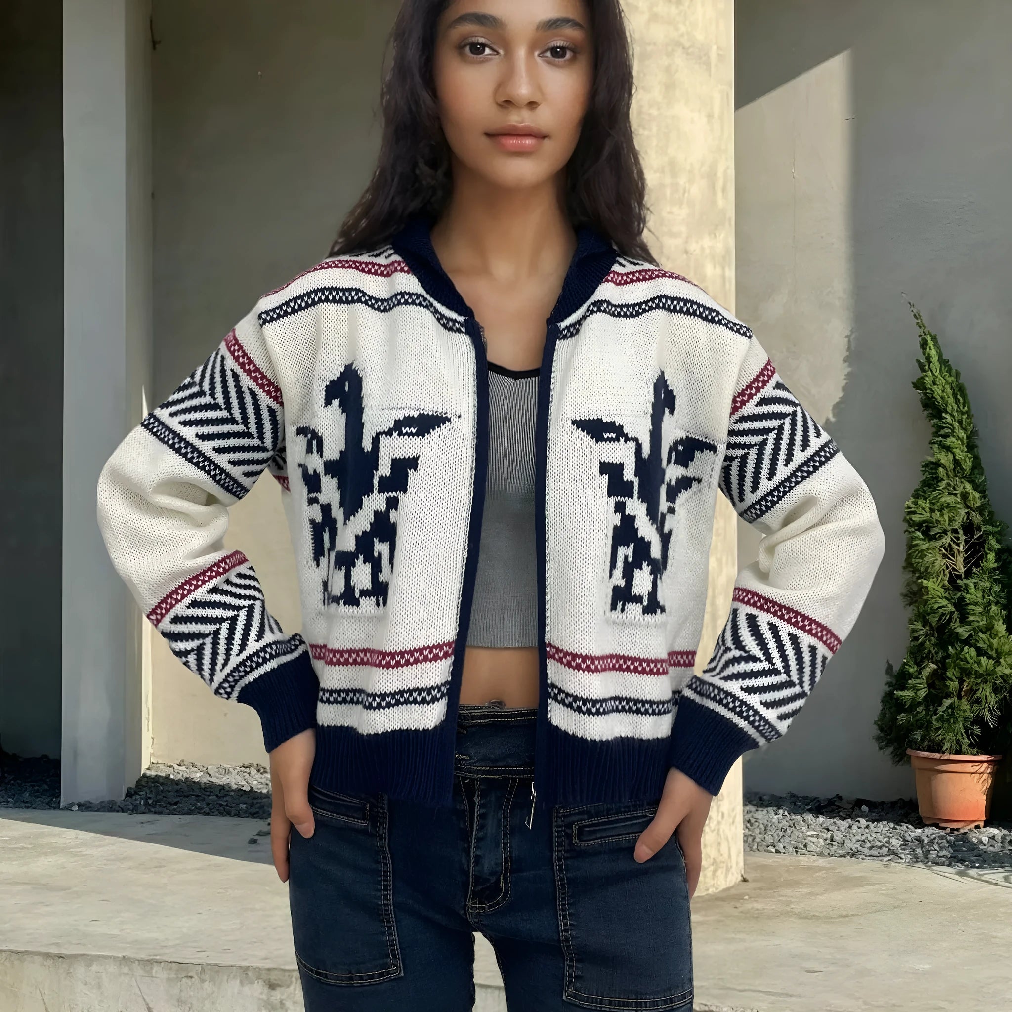 White women's zip cardigan with a contrasting striped jacquard lapel on a hanger.
