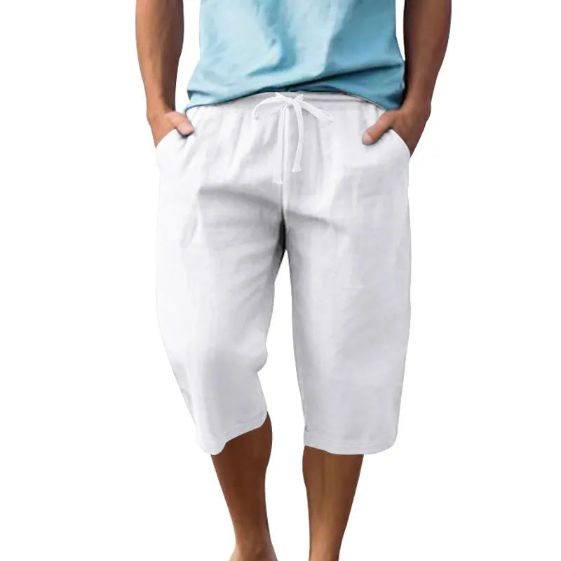 Men's solid colour linen shorts in a loose, cropped style on a drawstring waist.