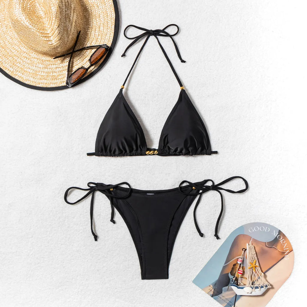 Black women's bikini swimsuit with metal bead accents and split design for swimming