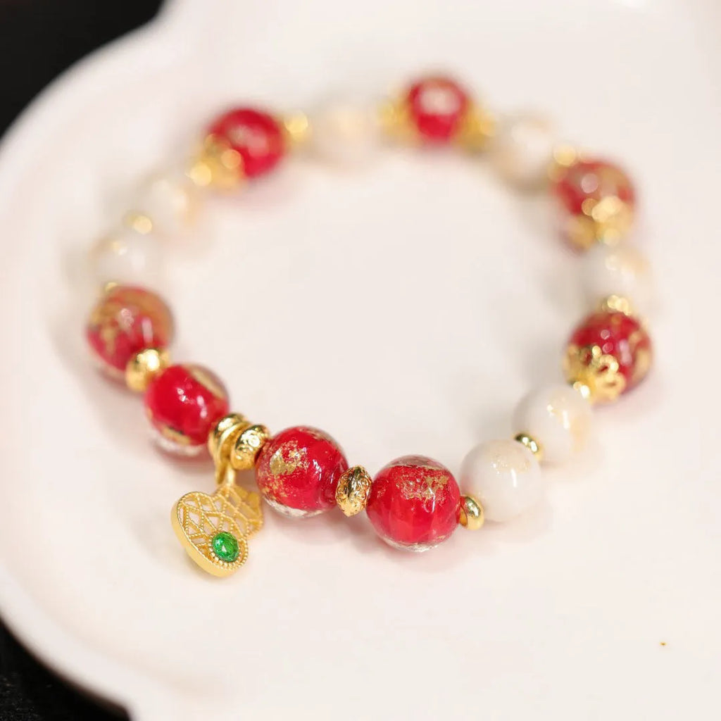 Gold foil coloured glaze ethnic bracelet with geometric design and God of Wealth pearl or porcelain hanging gourd