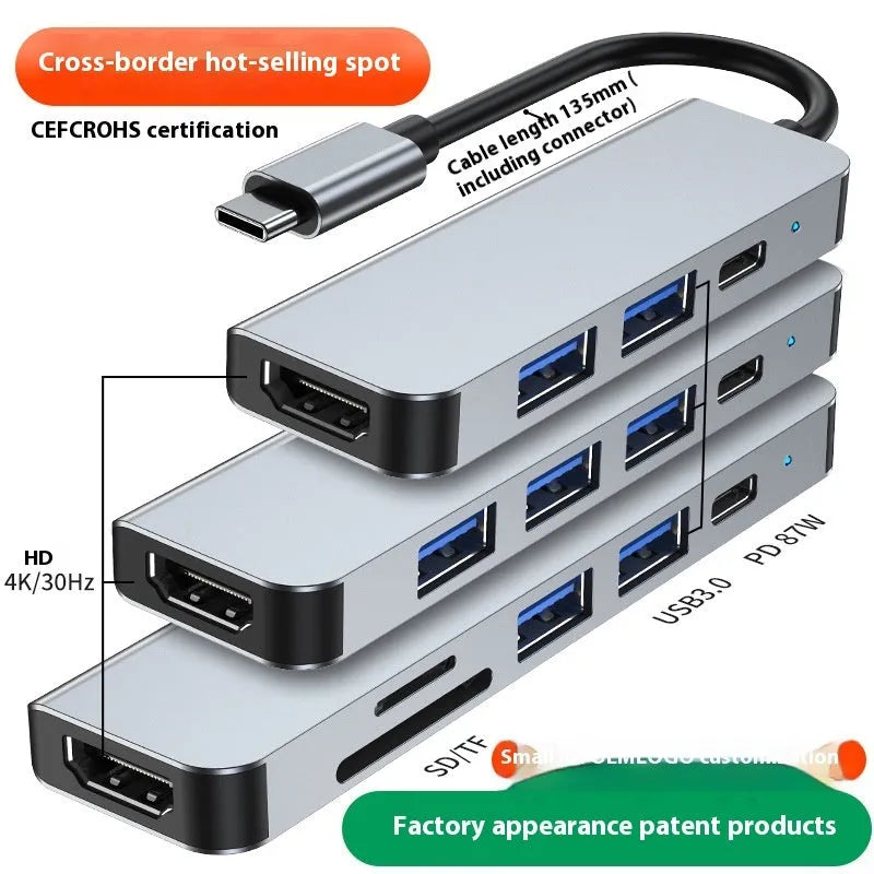 Compact silver USB-C expansion dock for laptops with multiple ports including HDMI and USB-A.