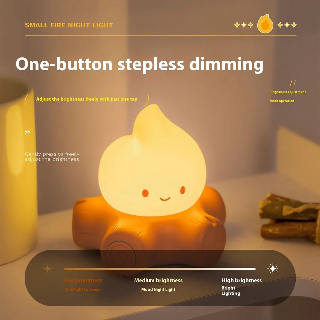Silicone small fire pile cartoon night lamp with yellow light on wooden surface
