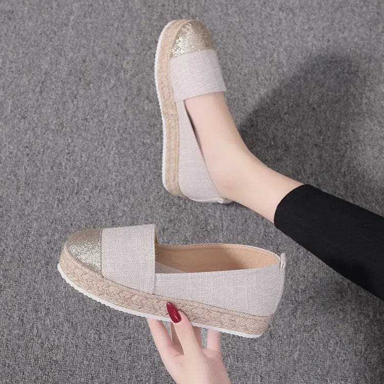 Beige and black canvas shoe covers with round toe design showing oversleeves construction