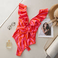 Women's deep V-neck one-piece swimsuit with mesh stitching and ruffled shoulders in a printing pattern.