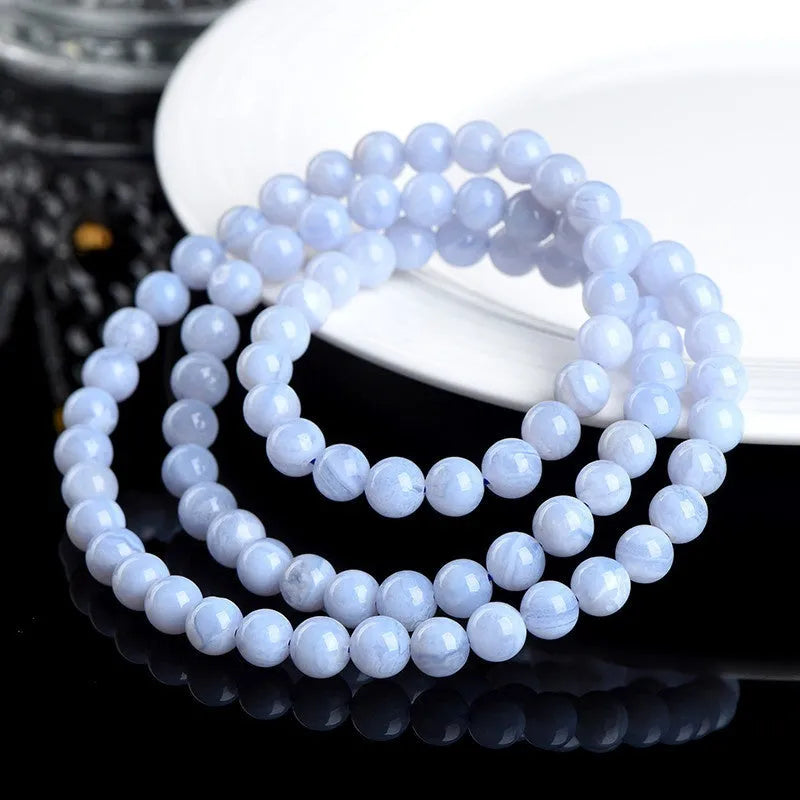 Blue agate bracelet with 6-6.8mm beads showing multi-circle pattern and scattered striped agate beads, Ruyi elements visible