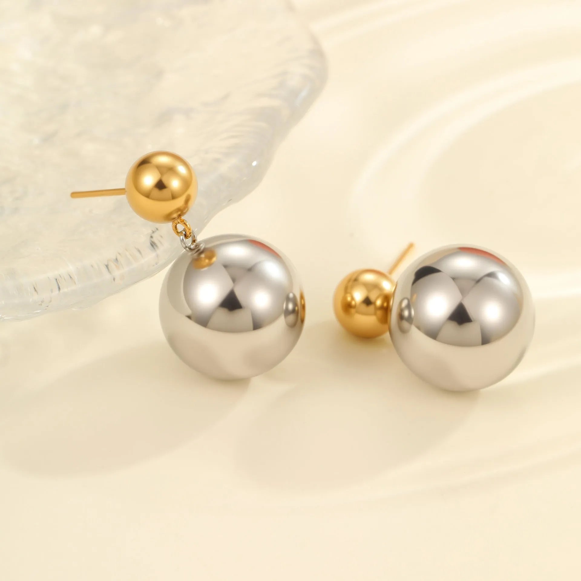 A pair of women's stud earrings with colour-blocked round geometric beads on stainless steel posts.