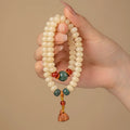 Cream topaz wooden bodhi root bracelet with 6x9mm flat round beads on wrist